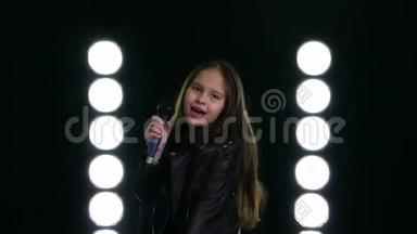 小女孩在舞台灯光前唱歌